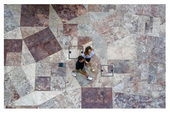 Two people walk hand in hand across the Plaza Vieja in Almería, Spain. Captured in a high-angle shot, their silhouettes stand out against a ground made of marble fragments in different shapes and colours.
---
Dos personas caminan tomadas de la mano por la Plaza Vieja de Almería. Fotografiadas en un plano picado, sus siluetas destacan en un suelo hecho con trozos de mármol de diferentes formas y colores.