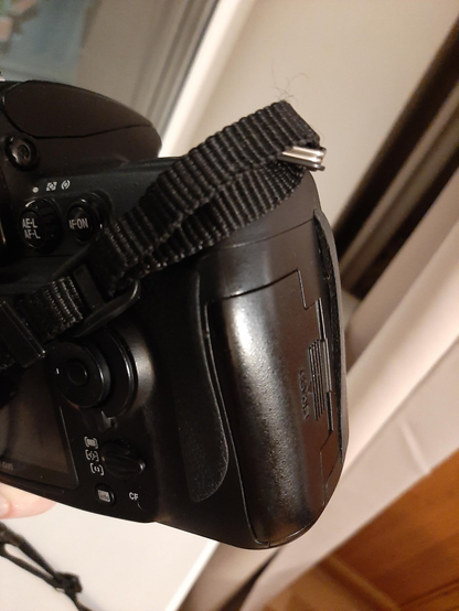 A picture of a rubber grip of Nikon D700 DSLR camera detaching from a body