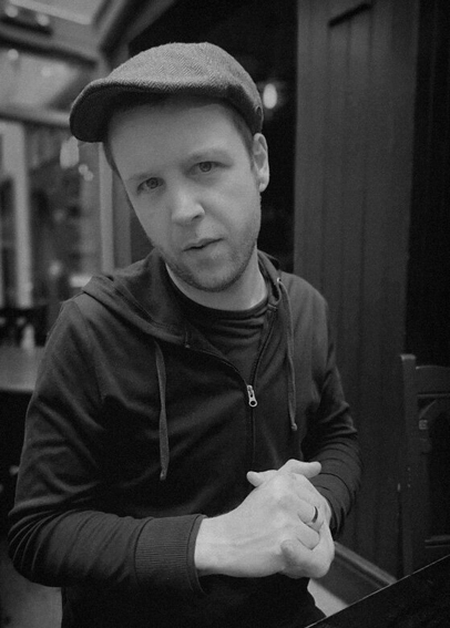 a fella with a flat cap and a hoodie on