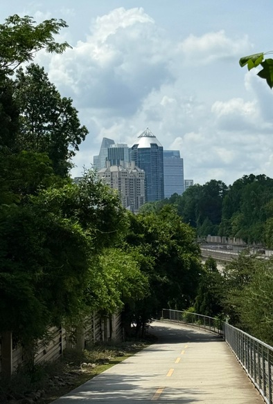 A paved walk path with skyscrapers in the distance