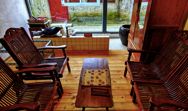 Mid-20th century period style room with chairs, table, and board game.