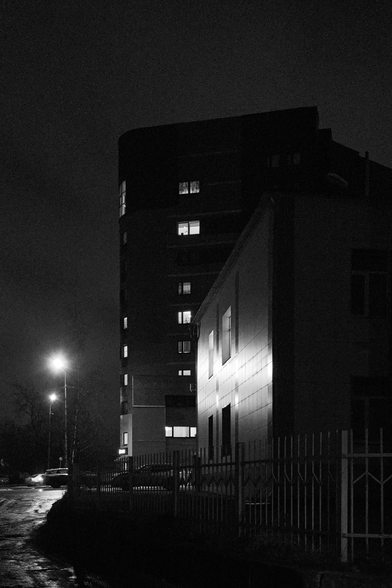 In the black-and-white photo, the buildings are illuminated by lanterns.