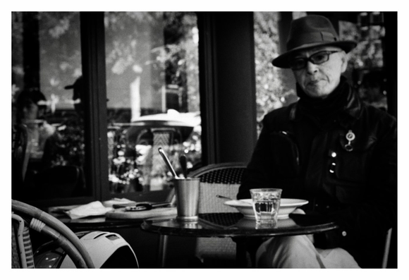 A Japanese man sitting outside an Italian restaurant.