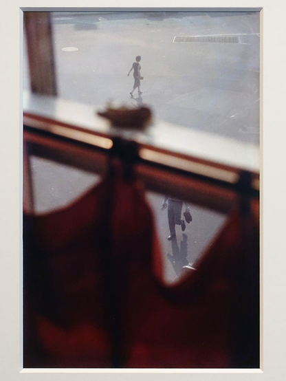 Achter een rood gordijn op de eerste verdieping wordt in New York 75 jaar geleden naar buiten gekeken. Je ziet vaag een vrouw weglopen en tussen de vouwen van het gordijn zie je nog gedeeltelijk een man met schoenen in zijn hand.