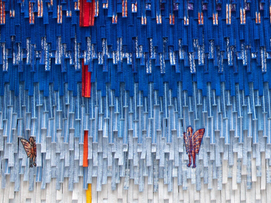 a vibrant abstract textile work comprised of fringed strips by Abdoulaye Konaté
