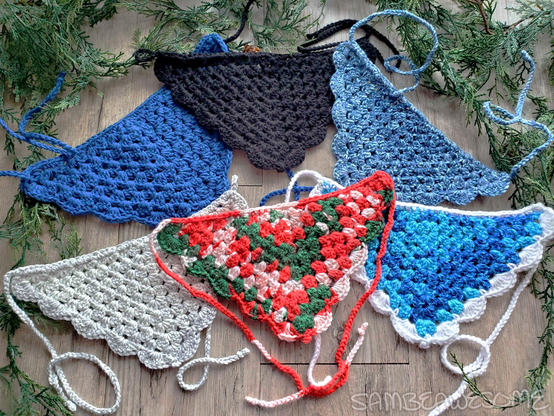 A photo of several handmade crochet bandanas. Each is a different color and in all sorts of color ways, all winter (with one Christmas) themed.