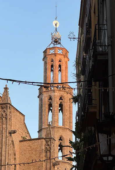 The moon rises above a tower of of Santa María del Mar 