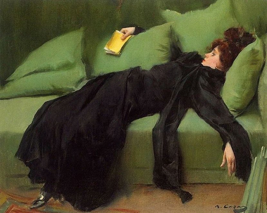 A woman in a voluminous, all-black dress with long, flowing sleeves is dramatically draped and semi-reclined on a bright, pea-green sofa. Her head rests on a pillow, and her arm hangs down toward the floor. She holds a small yellow book in her right hand.
