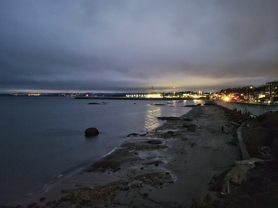 This image shows a portion of the shoreline at the south end of Victoria, looking west toward Ogden Point. A night shot, it's bright enough to see that the tide is lower than usual.