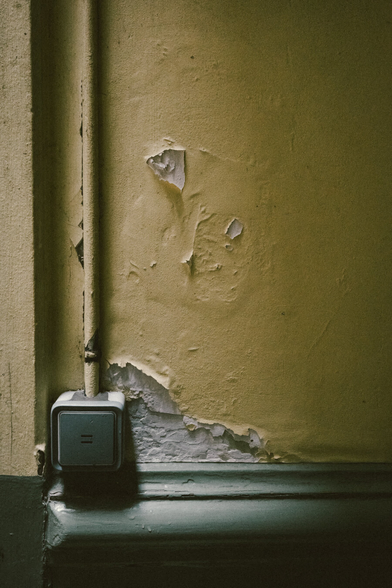 An old light switch on a decaying wall