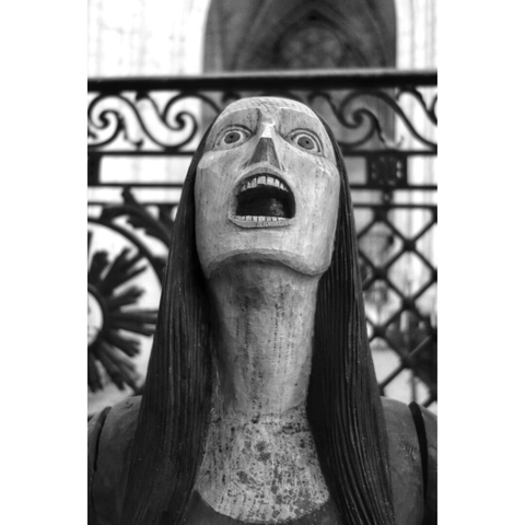 Black and white picture of a wood sculpture by French artist François Brochet. A woman is crying out loud with her eyes wide open and a terrified face.