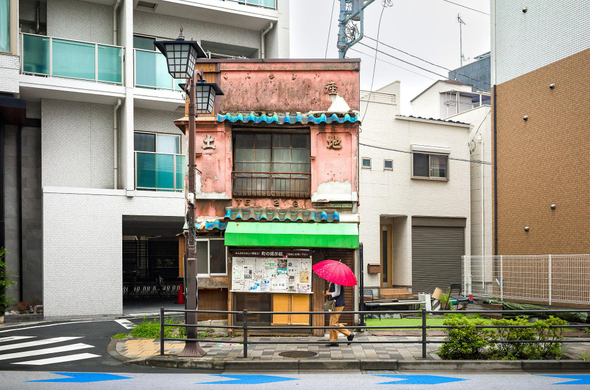 A run-down old building in the middle of newly built ones. It looks like a piece of older Tokyo was cut and pasted there, tho the logic is quite the opposite. The Guardian caption: ' This very old building was the last one standing as Arakawa ward, Tokyo, was slowly but surely redeveloped. Until this year that is when it was also demolished '