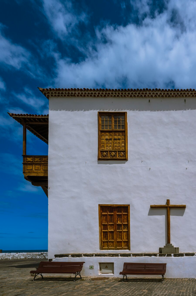 Whitewashed walls, hand-carved wooden windows and balcony, and the simple wooden cross of Casa de la Aduana (Customs House) against the blue sky on the shores of the North Atlantic Ocean in Puerto de la Cruz, Tenerife
Captured by Komeil Karimi