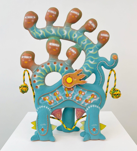 A ceramic sculpture by Chenlu Hu featuring an abstract, mythical character with numerous heads on a serpentine, teal body