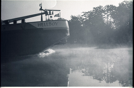 ship with the name Hellboy passing by in the fog on the river Maas
