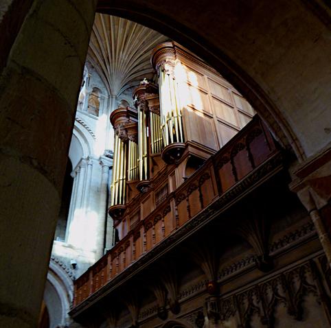 Foto van kerkorgel, gezien tussen bogen door