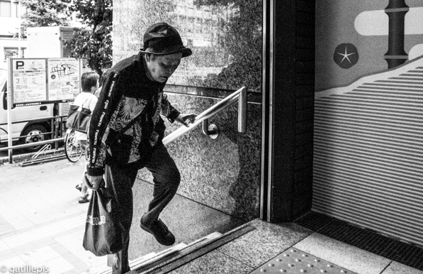 Home gran pujant unes escales amb esforç