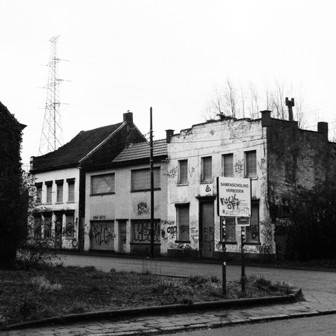 Bâtiments abandonnés de la ville de Doel en Belgique. Sur un panneau « samenscholing verboden » (rassemblements interdits) sont taggés les mots FUCK OFF