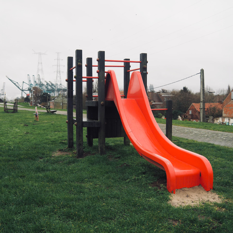 Un toboggan rouge vif et herbe verte
