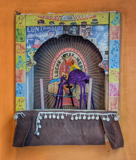 The artwork is mounted on a bright orange wall and has been described in the post.