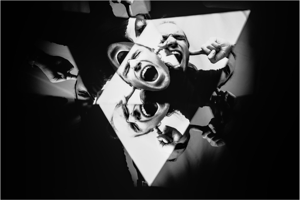 Schwarz-Weiß-Bild von Robert Person die sich die Ohren zuhält, mehrfache Kaleidoskopartige Reflexionen