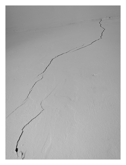 A significant jagged crack on a wall.
