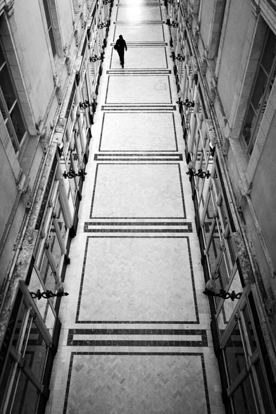 View from above of a long classy hallway and one person walking it