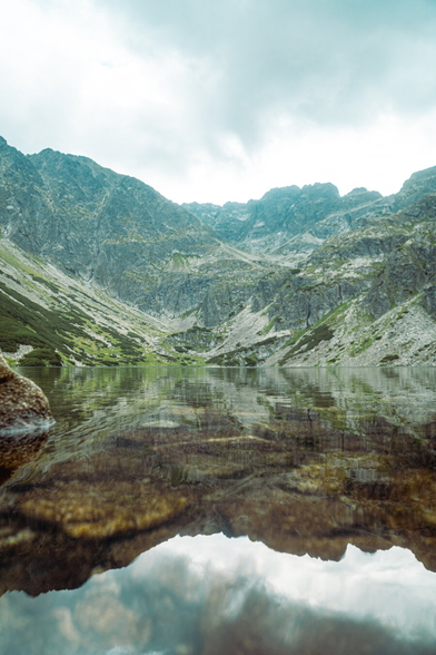 High, towering mountains above the lake. The mountains are reflected in the water.