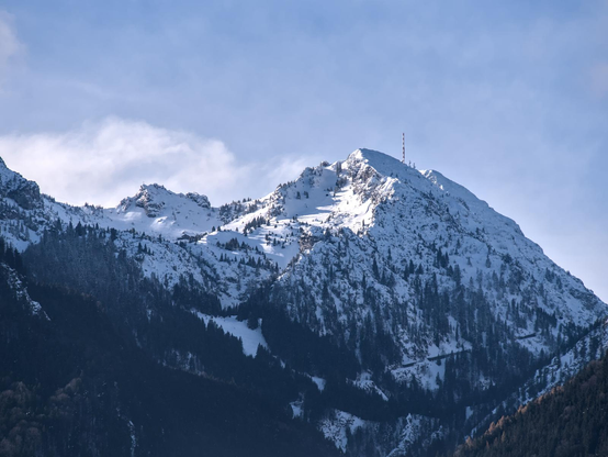 The Wendelstein mountain in Bavaria, Germany covered in snow. There is a atenna on top of the mountain.