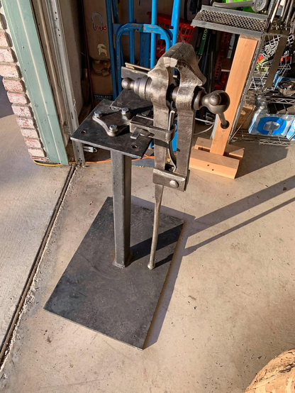 A restored blacksmith post vise from the early 1900s, attached to a welded steel stand.