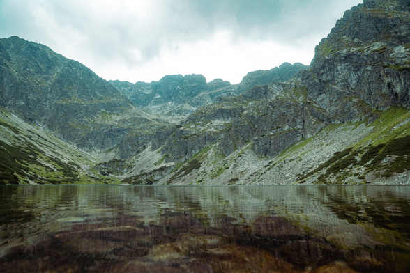 High, towering mountains above the lake. The mountains are reflected in the water.