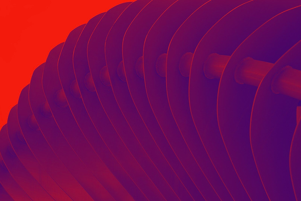 A color photo showing a fan-like sculpture in deep red tones.