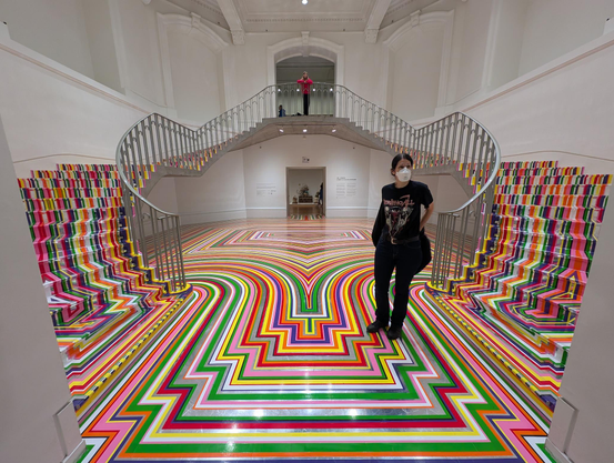 Die Stufen des rundgeschwungenen Treppenhauses der Vancouver Art Gallery sind vollständig mit einem bunten Muster verstehen. 