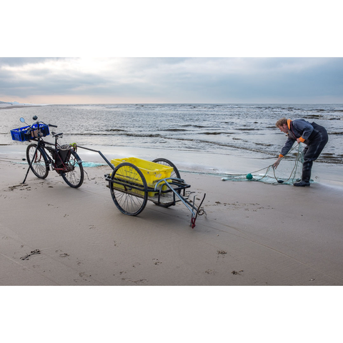 Colourphoto of a shrimp beach fisherman on the North Sea beach near Bergen aan Zee in The Netherlands, December 2025.