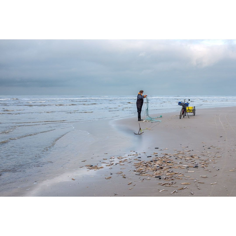 Colourphoto of a shrimp beach fisherman on the North Sea beach near Bergen aan Zee in The Netherlands, December 2025.