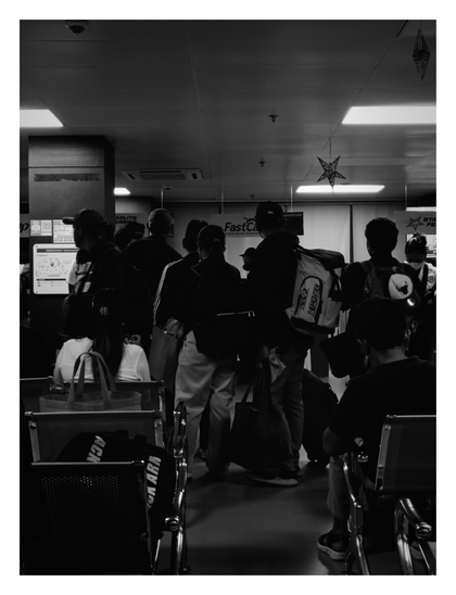 A group of travelers waiting in what appears to be a ferry or transport terminal. The figures are heavily silhouetted against bright overhead lighting and signage (including "FastCat" and "STARLITE FERRIES") as they stand near rows of metal seating. - Google Gemini Latest