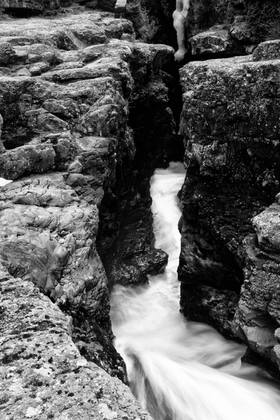 Black and white shot of a thin river canyon