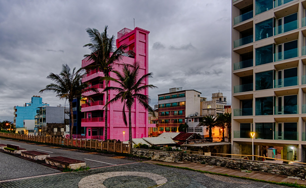 Road near the port at nightfall with palm trees and colorful apartment buildings.