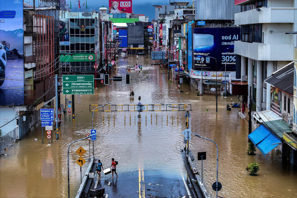 A drone view shows people walking in a flooded street.