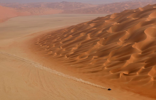 Dakar Rally in Saudi Arabia alongside huge dunes.