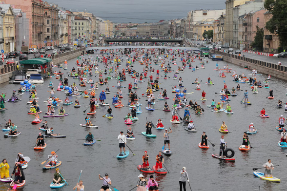 Participants make their way on the Fontanka river during the Fontanka SUP stand up paddle boarding festival in Saint Petersburg.
