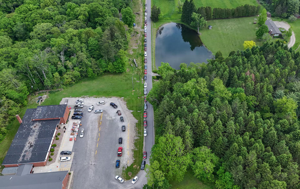 A drone view of vehicles lining up for fresh produce provided by the Mid-Ohio Food Collective at a monthly drive-thru produce pantry outside Faith Baptist Church in Belle Valley, Ohio.