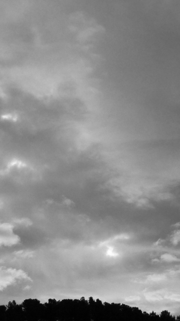 Fotografía en blanco y negro de una montaña recortada contra el cielo nublado