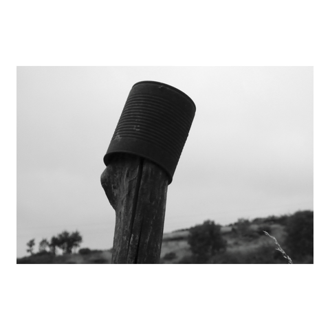 Rusty tin can on fence post. (Version françæ) Boîte de conserve rouillæ sur piquet de clôture.