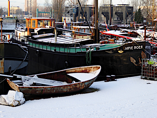 Foto van sneeuw op kade en boten