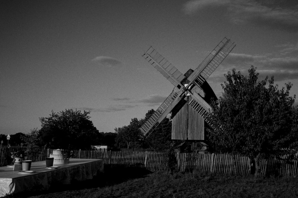 Eine Mühle aus Holz mit einer überdimensionierten Tafel mit Torte.