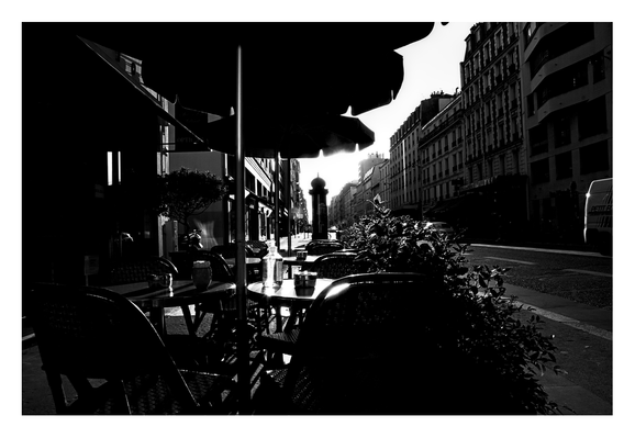 Daylight monochrome photography.

Early morning café in the endless streets of the city, sun playing hide and seek with the side-walk artefacts, the vanishing point is far away but time is on our side, it's summer after all.