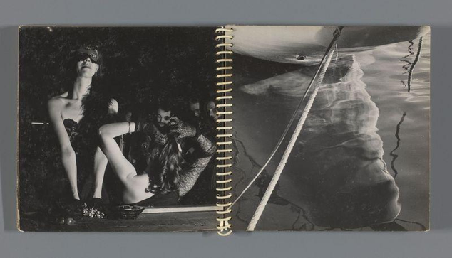 The image displays a spiral-bound book or notebook containing two black and white photographs. On the left page, there is a person sitting on what appears to be the ground with legs crossed, wearing dark attire that includes stockings and possibly high heels. The individual has their arms wrapped around themselves and seems contemplative. Another figure can be partially seen behind them in a similar setting.

The right page features two people near water; one of whom is leaning against something while looking into the distance or at someone else out of frame, with sunglasses on. In front of this person floats an object resembling part of a boat or raft on calm waters that reflect clouds and ropes. The overall mood seems to be contemplative and artistic.

The photograph itself has a watermark indicating it may belong to Feest (https://www.flickr.com/photos/15437290@N08/) with Ed van der Elsken's name associated, suggesting the image might have been taken around c. 1948 - c.