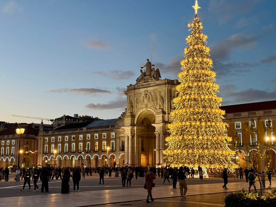 Large public square with a lit-up archway and large illuminated Christmas Tree
