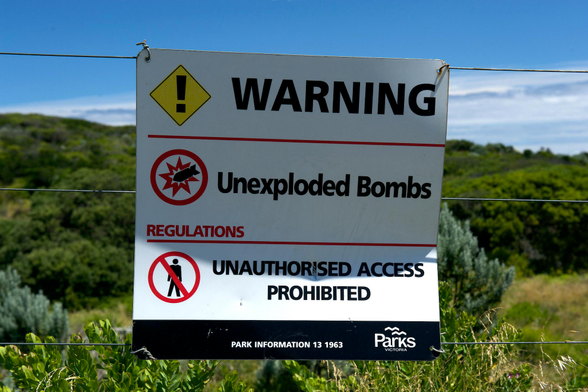warning sign, unexploded bomb warning, white sign, black text, sunny day, blue sky, danger sign, National Park, 